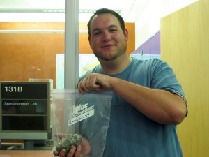 Lee takes the bagged rock into the spectrometer lab